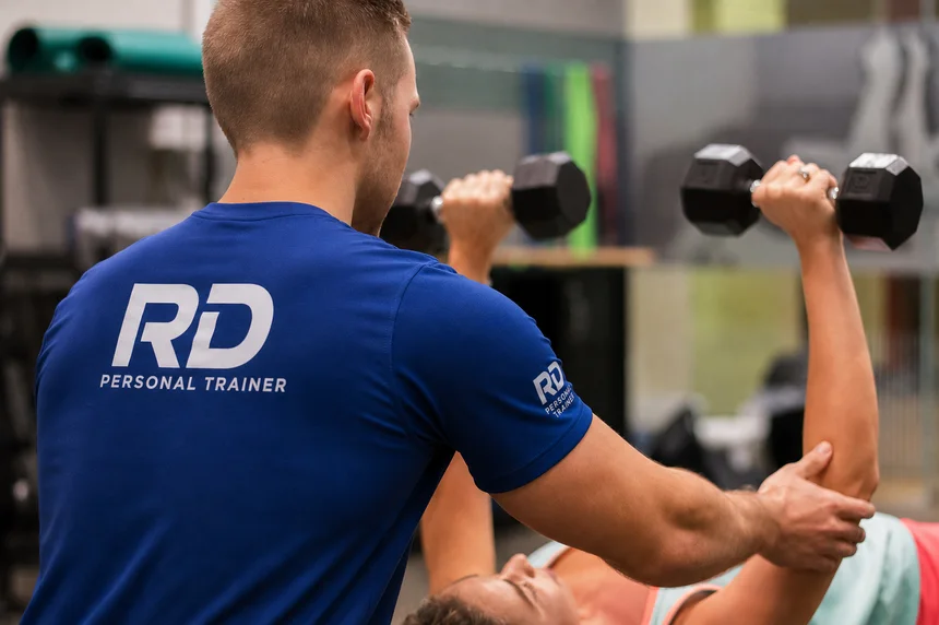 Personal trainer da RD acompanhando série de musculação